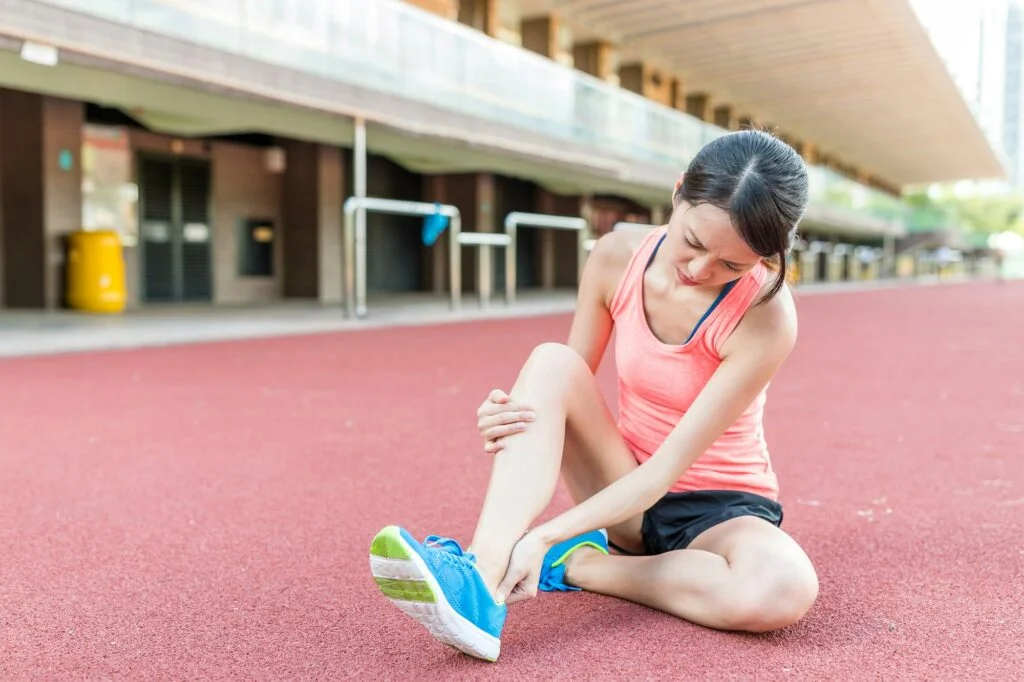 Person holding their ankle in pain